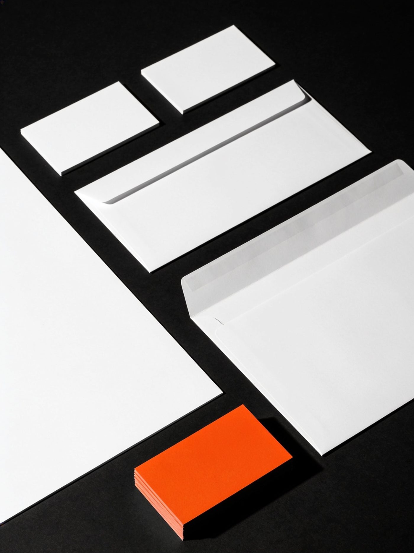 Geschäftsausstattung-Flatlay – ein Stapel Visitenkarten in Signal-Orange